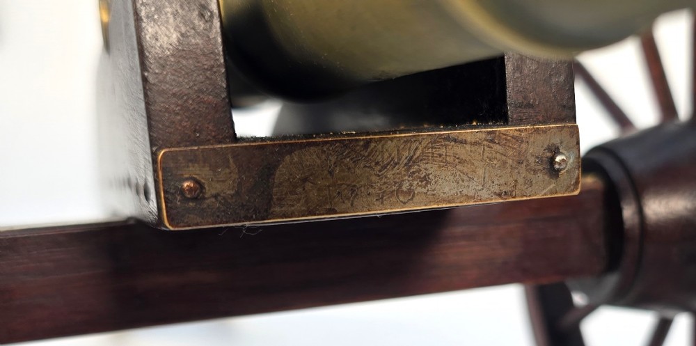 A pair of 1920s model field cannons featuring cast brass barrels mounted on dark wooden spoked-wheel carriages. View X