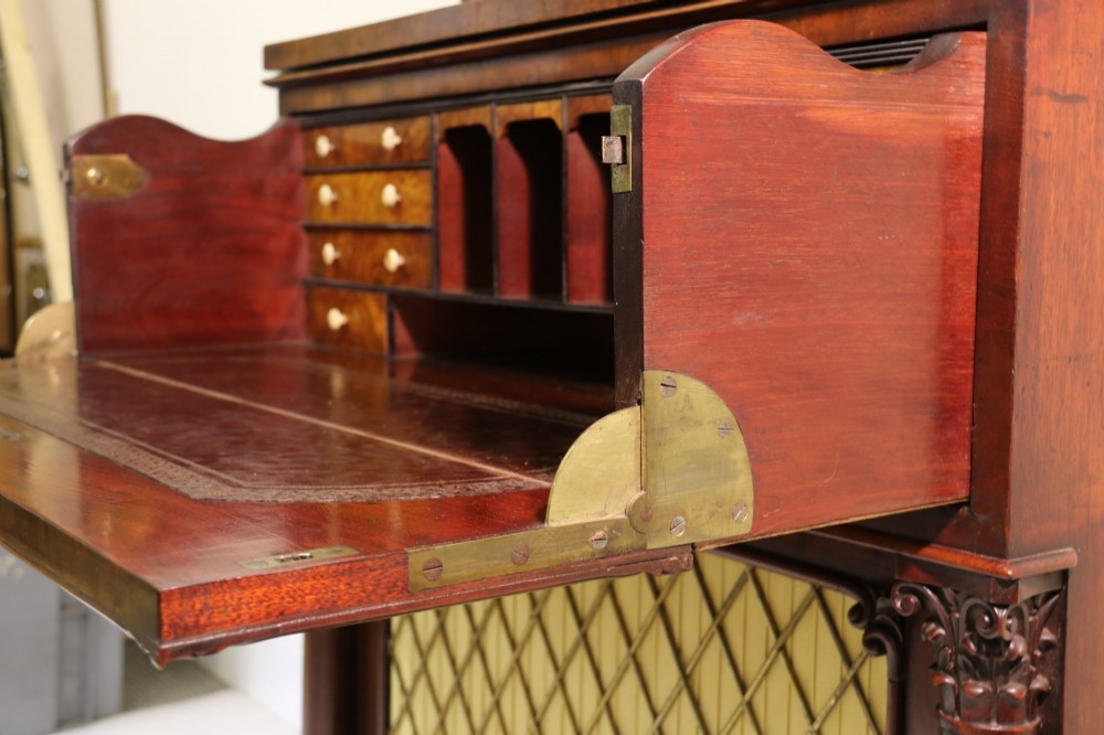 A Regency mahogany secretaire bookcase featuring a glazed upper display cabinet, a drop-front writing drawer with a fitted interior, and reeded side columns. View V