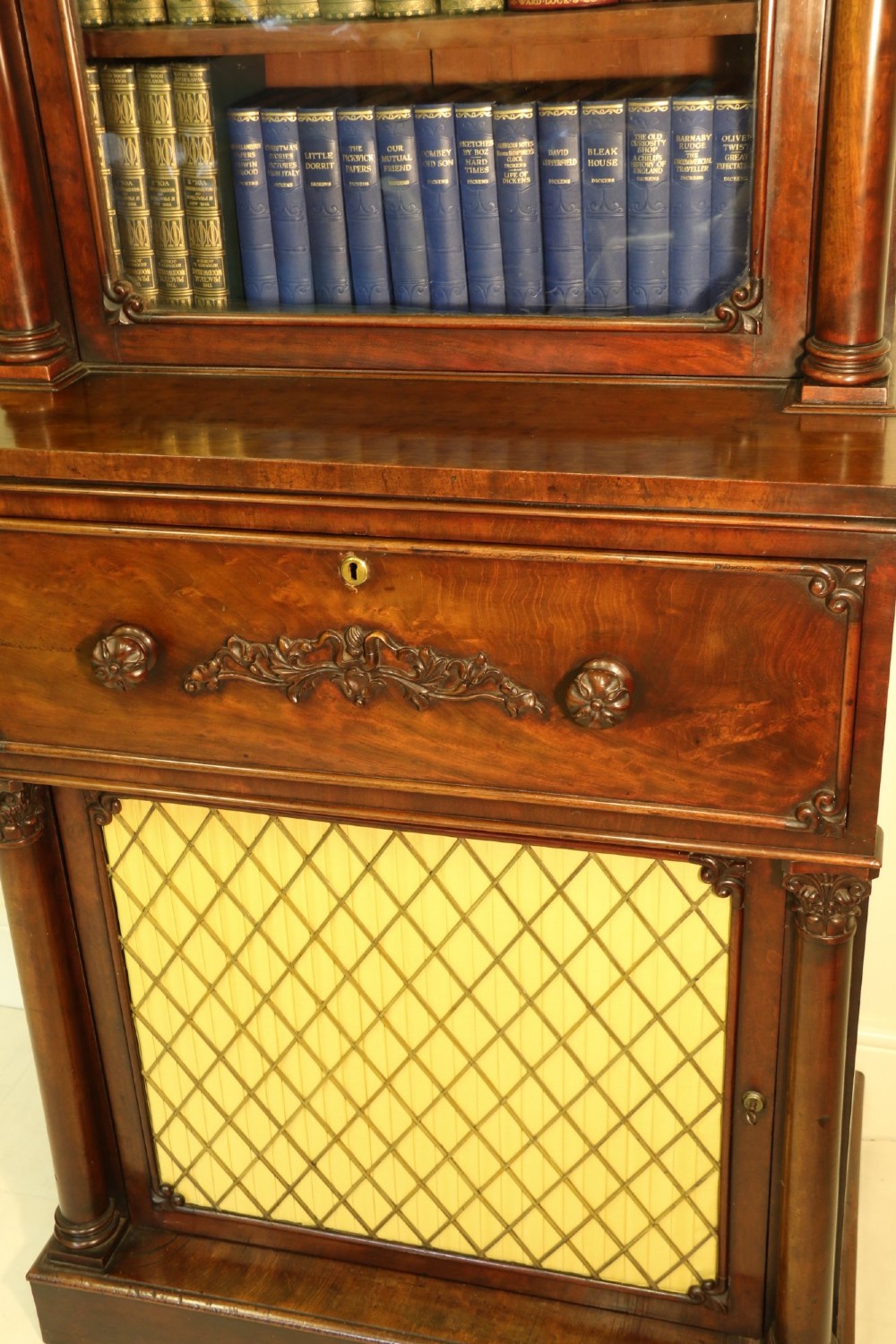 A Regency mahogany secretaire bookcase featuring a glazed upper display cabinet, a drop-front writing drawer with a fitted interior, and reeded side columns. View VIII