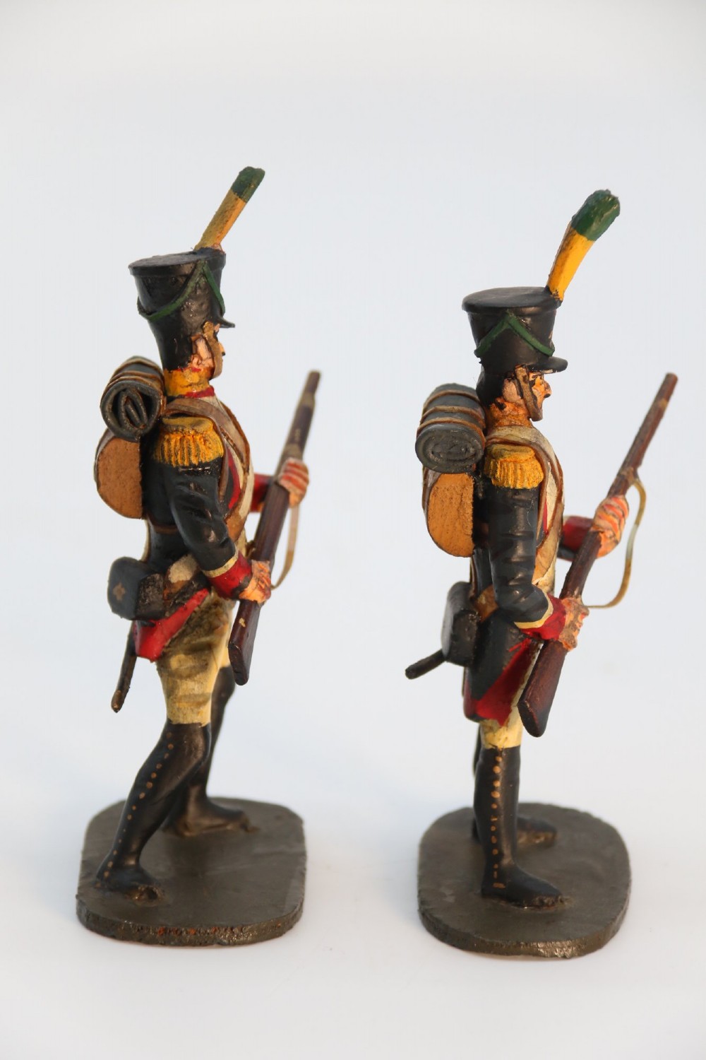 A group of ten hand-carved and painted wooden figures depicting Napoleonic infantry soldiers with muskets standing on individual oval bases. View II