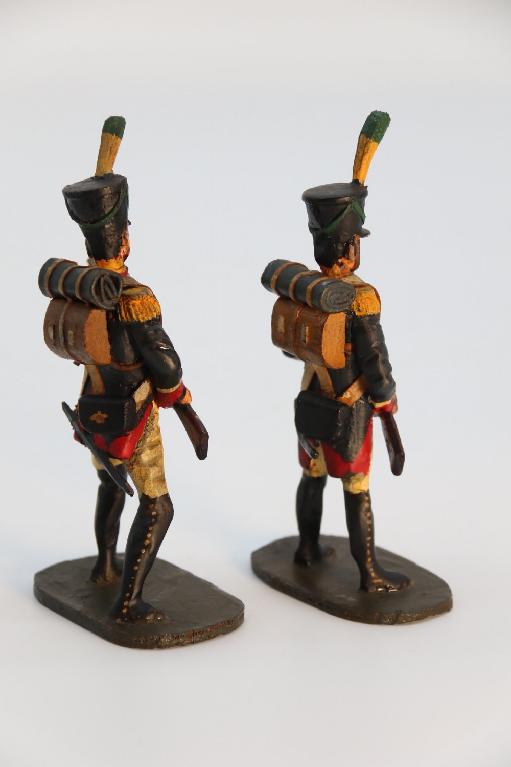 A group of ten hand-carved and painted wooden figures depicting Napoleonic infantry soldiers with muskets standing on individual oval bases. View III