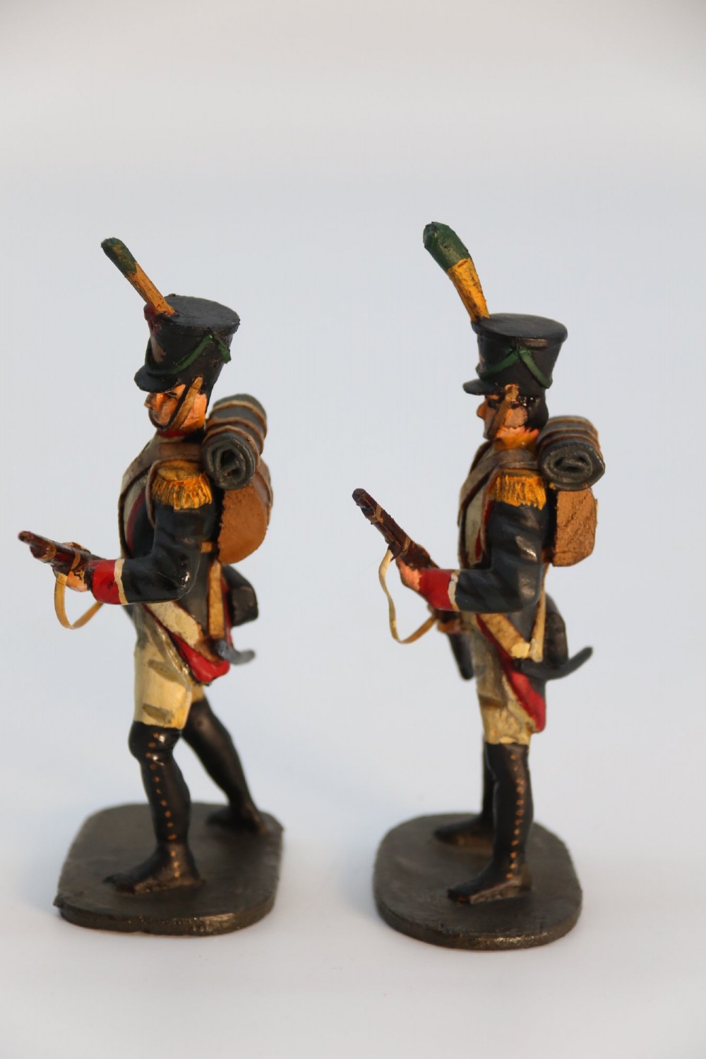 A group of ten hand-carved and painted wooden figures depicting Napoleonic infantry soldiers with muskets standing on individual oval bases. View VI