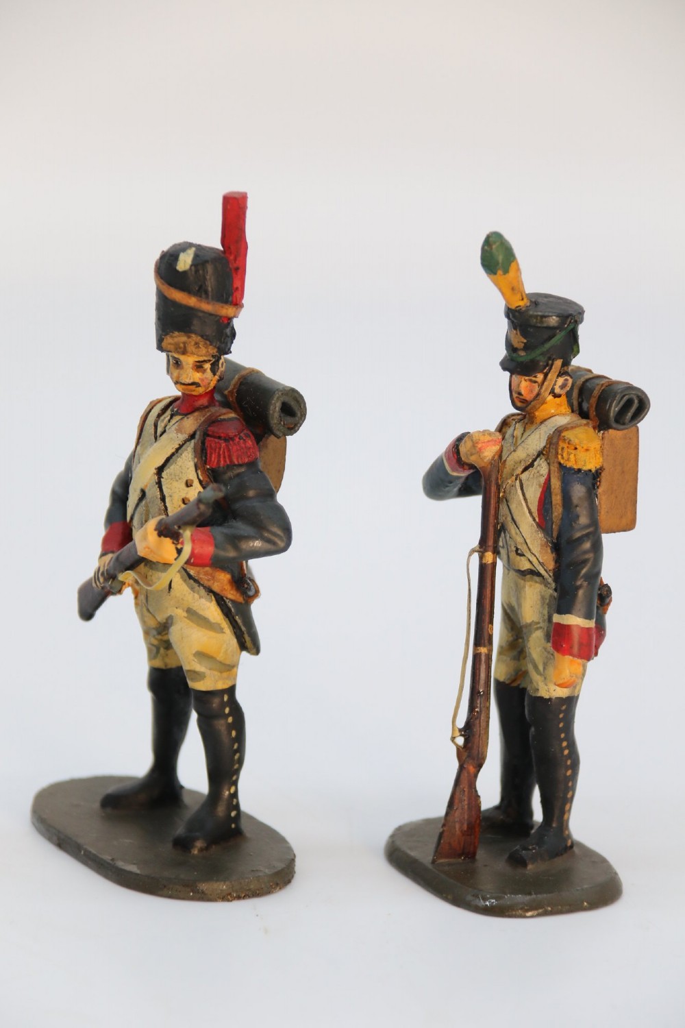 A group of ten hand-carved and painted wooden figures depicting Napoleonic infantry soldiers with muskets standing on individual oval bases. View XIII