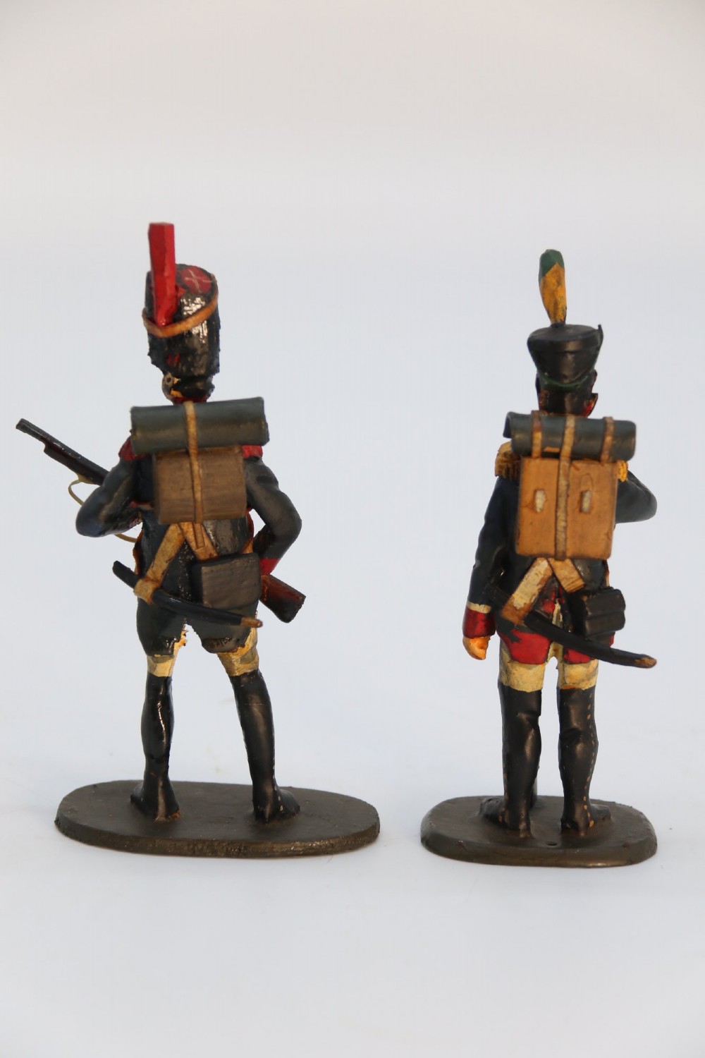 A group of ten hand-carved and painted wooden figures depicting Napoleonic infantry soldiers with muskets standing on individual oval bases. View XV