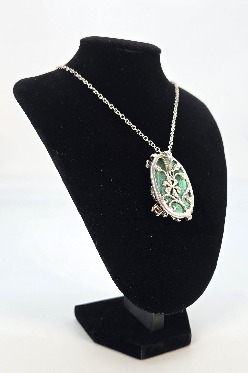An oval green banded malachite pendant set in silver with floral enamel embellishments and small accent stones on a fine chain. View IV