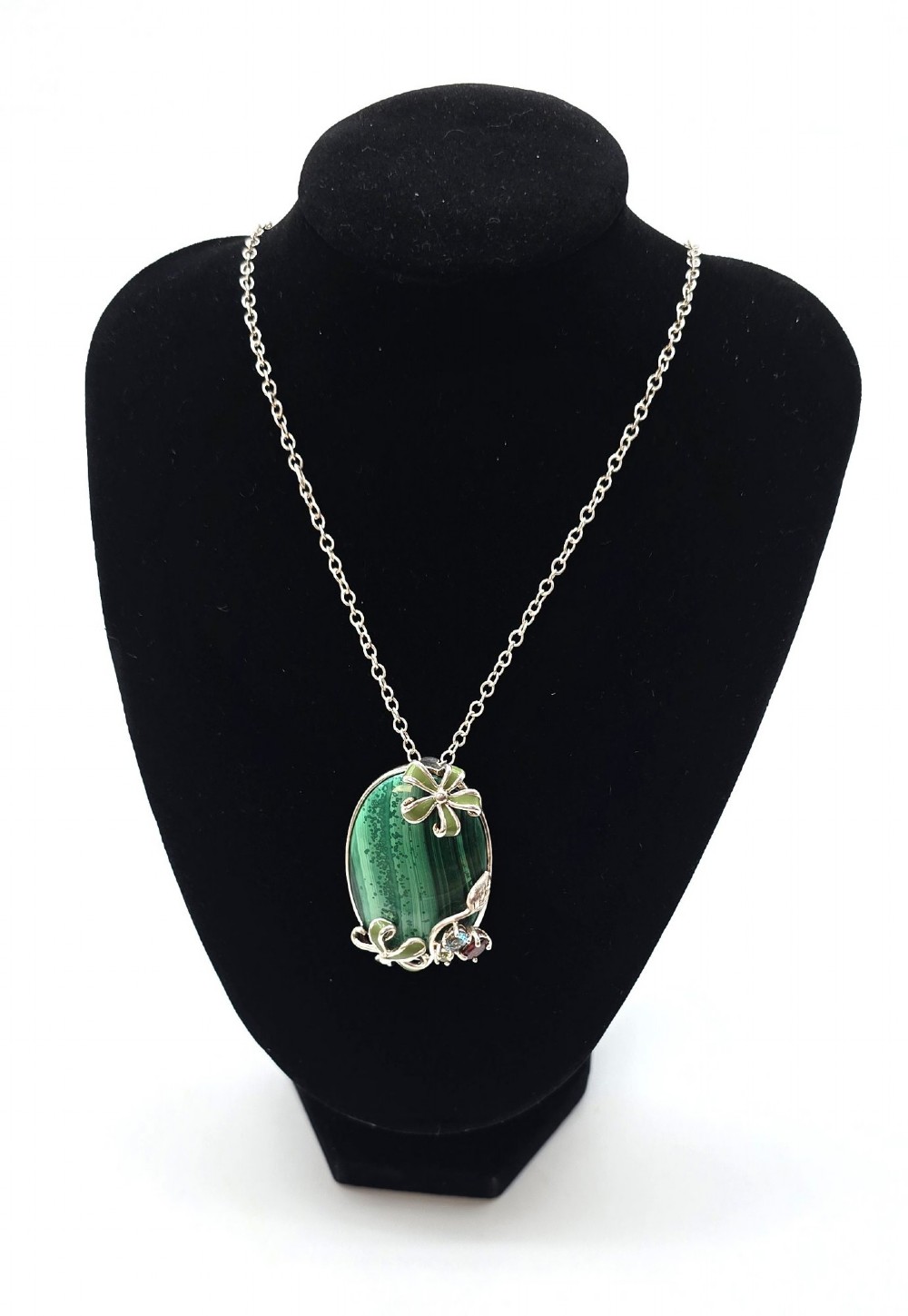 An oval green banded malachite pendant set in silver with floral enamel embellishments and small accent stones on a fine chain. View X