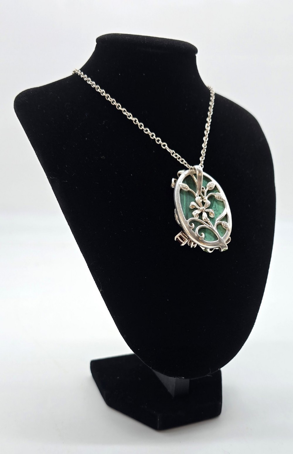 An oval green banded malachite pendant set in silver with floral enamel embellishments and small accent stones on a fine chain. View XI