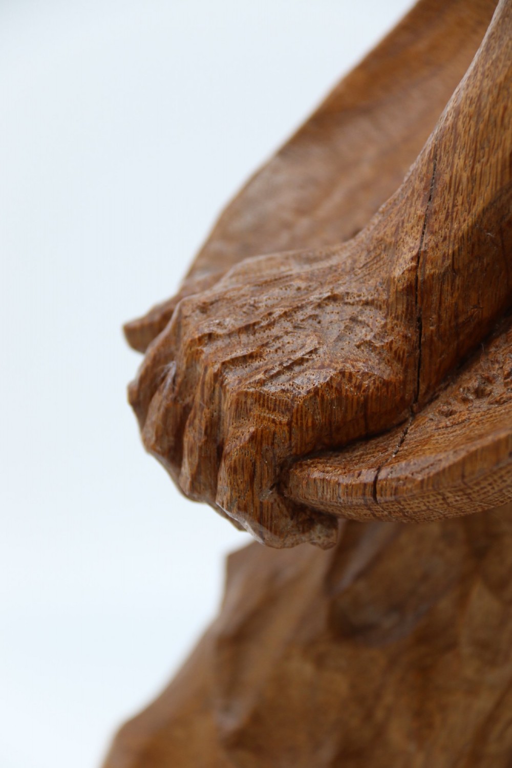 A hand-carved golden oak wooden sculpture of a male farm worker standing on a carved naturalistic base while holding a shallow tray. View XII