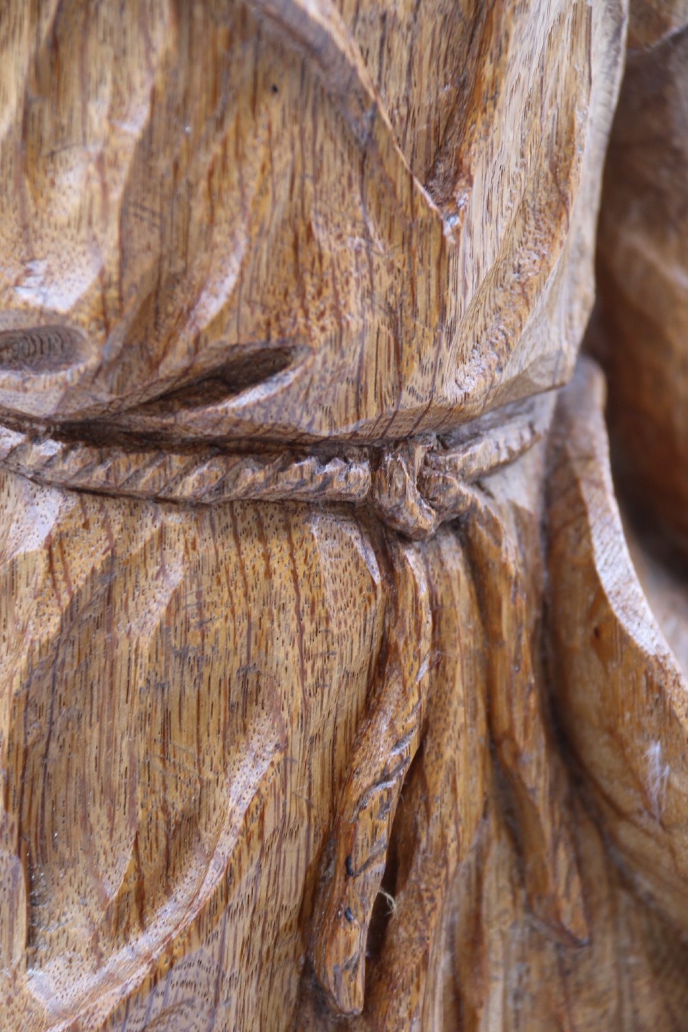 A hand-carved golden oak wooden sculpture of a male farm worker standing on a carved naturalistic base while holding a shallow tray. View XIV
