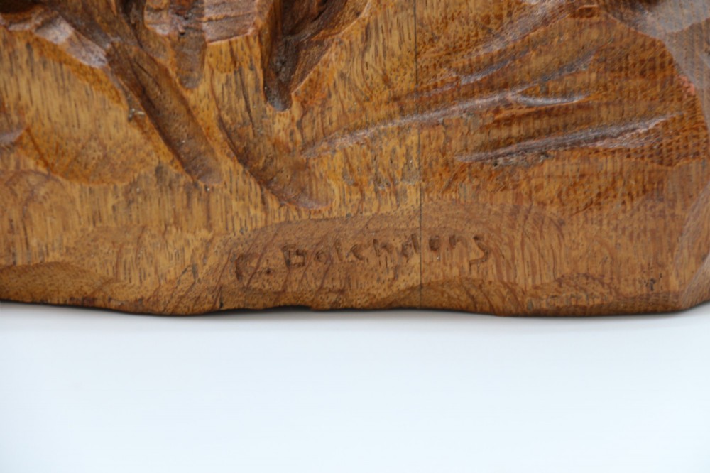 A hand-carved golden oak wooden sculpture of a male farm worker standing on a carved naturalistic base while holding a shallow tray. View XV