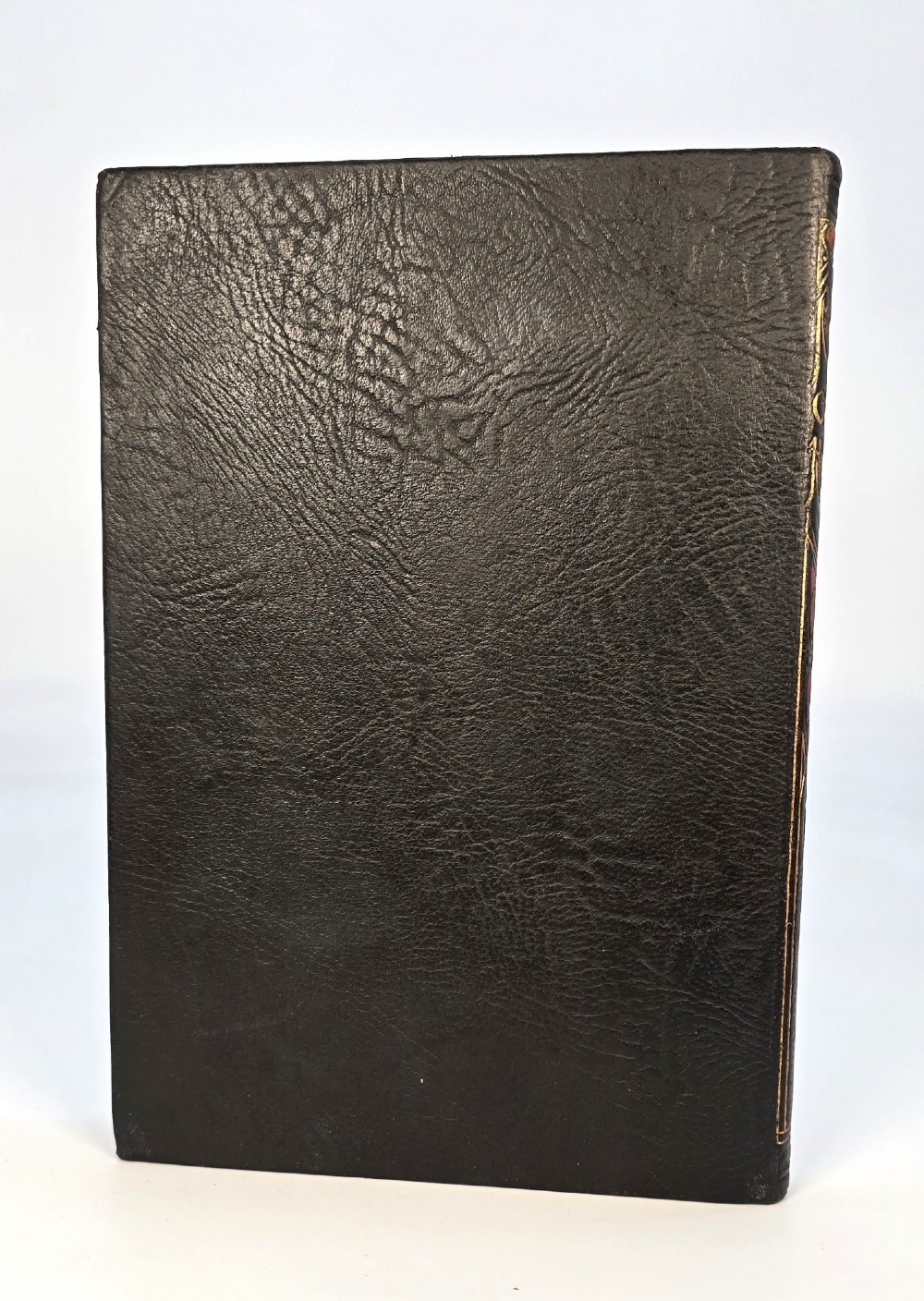 An Edwardian black leather bound edition of the Rubaiyat of Omar Khayyam featuring gilt and red embellished lettering with geometric corner tooling. View II