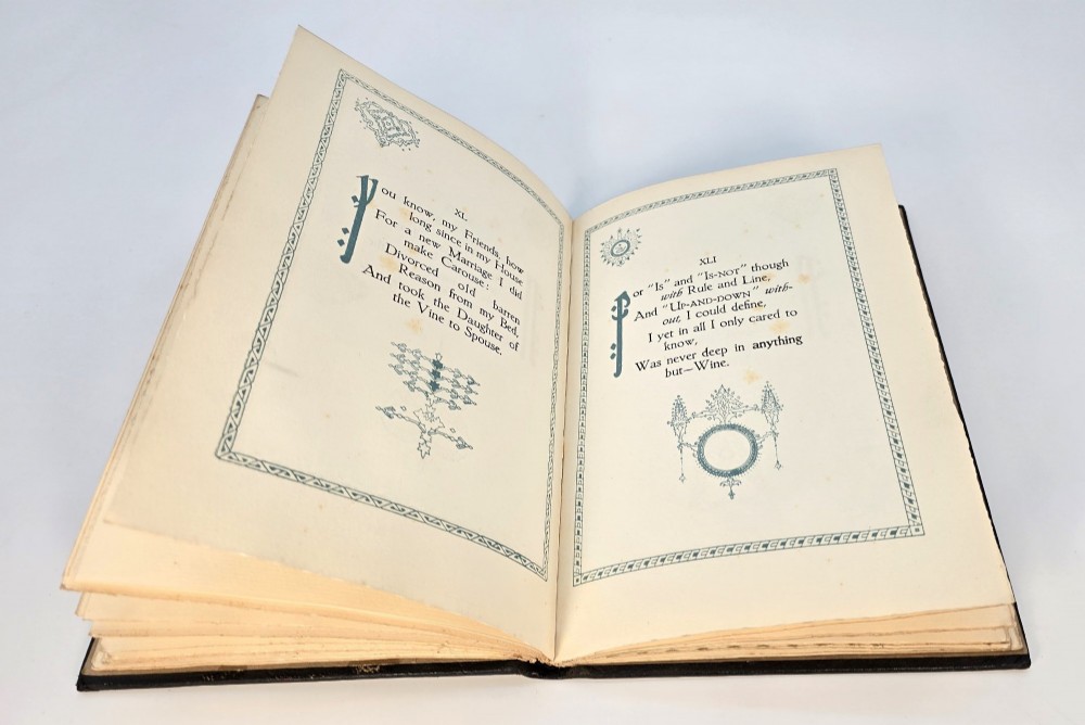 An Edwardian black leather bound edition of the Rubaiyat of Omar Khayyam featuring gilt and red embellished lettering with geometric corner tooling. View IX