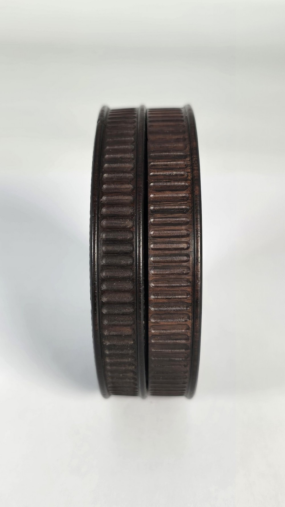 A circular black ebony snuff box with intricate engine-turned geometric patterns and raised beaded details on the lid. View XII