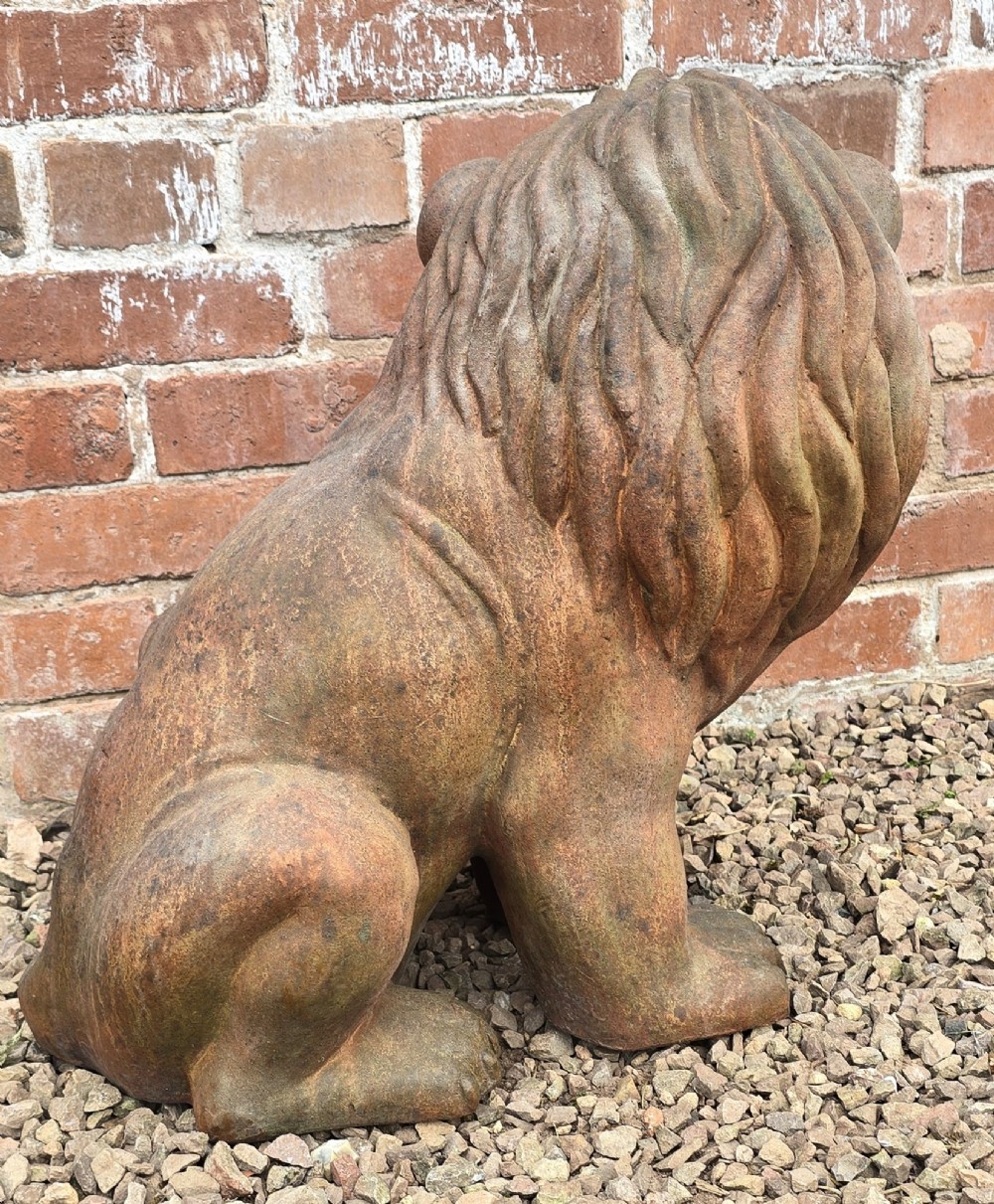 A pair of hand-sculpted Italian terracotta seated lions with weathered patination. View X