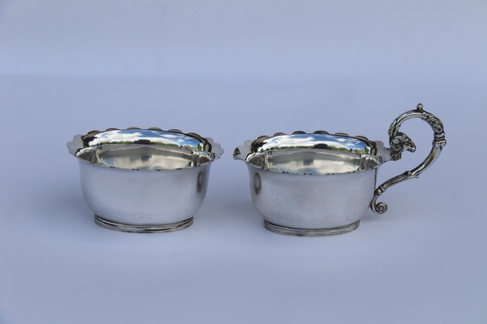 A silver-plated double frame holding two floral porcelain plates alongside a fitted cream jug and sugar bowl. View IX