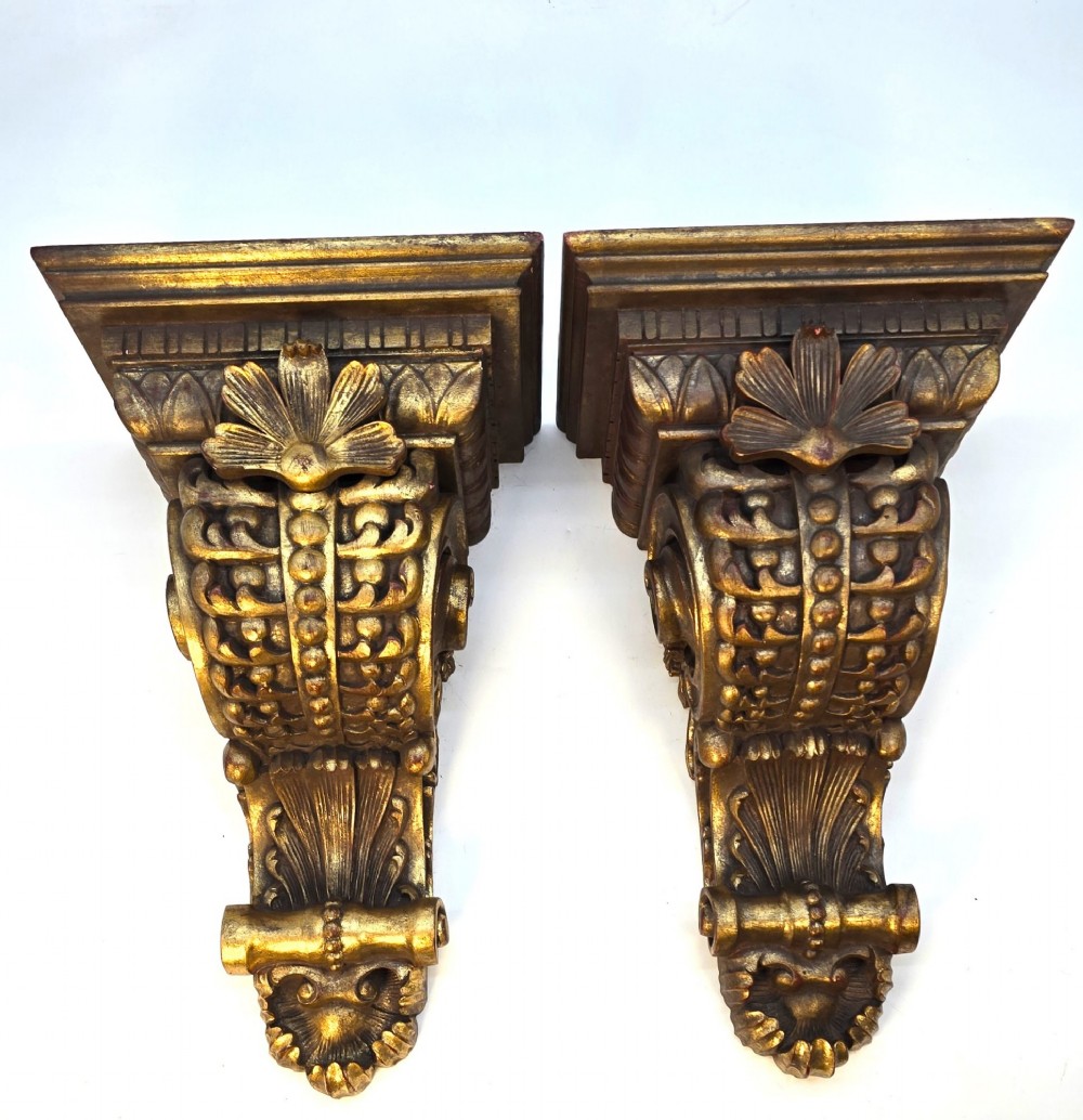 Pair of ornate Italian carved giltwood wall brackets featuring palmette leaf motifs and scrollwork finish.