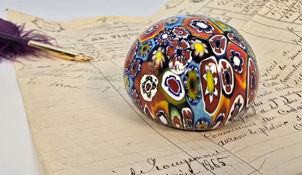 A spherical glass paperweight featuring a vibrant interior arrangement of colourful geometric and floral millefiori cane patterns. View IX