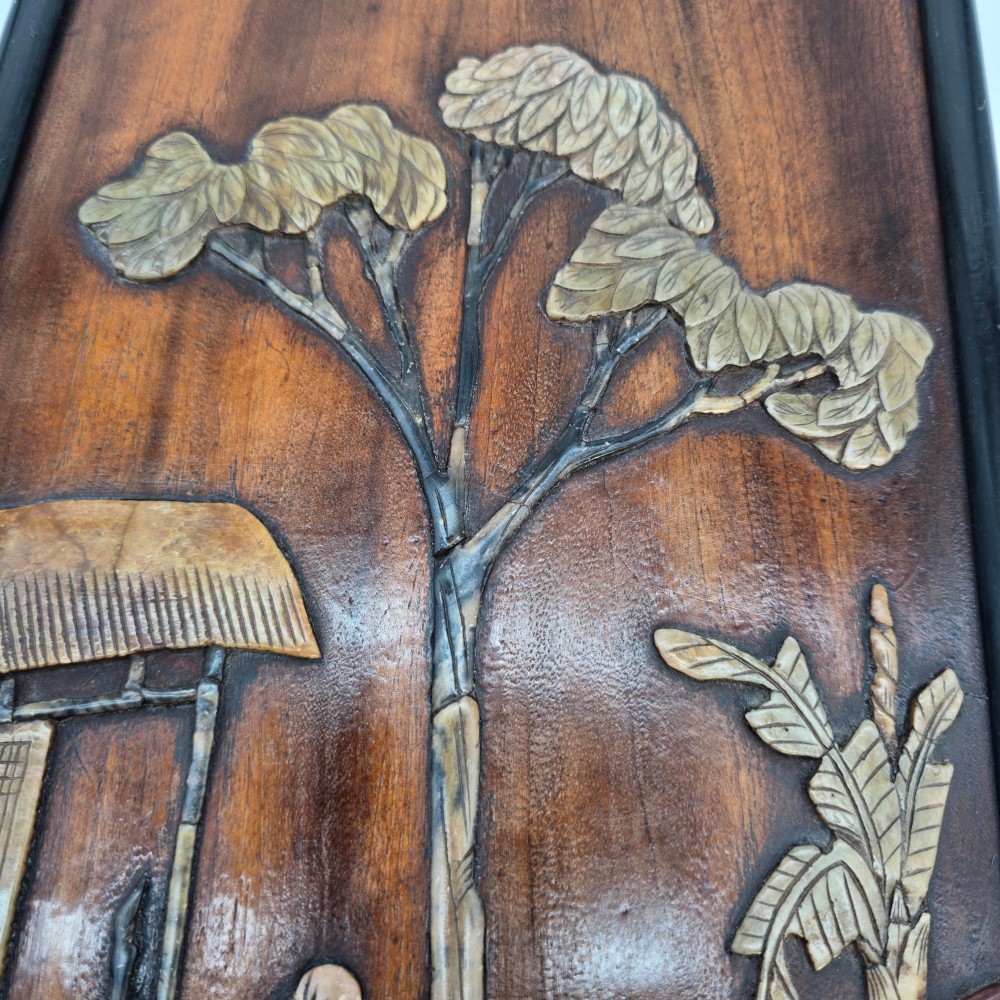 A vertical rectangular dark wood panel displaying a carved multi-coloured hardstone relief scene of figures beneath a tree and architectural structure. View IX
