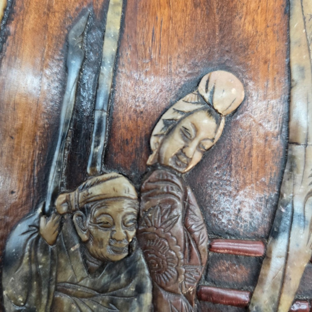 A vertical rectangular dark wood panel displaying a carved multi-coloured hardstone relief scene of figures beneath a tree and architectural structure. View XIII