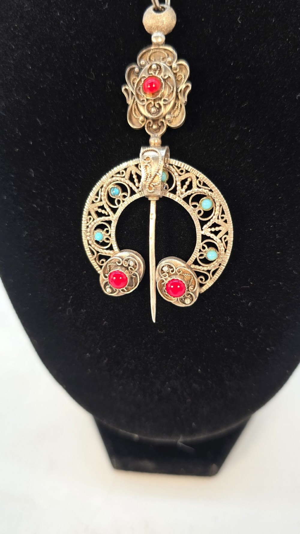 An antique late nineteenth-century French silver pendant in an Ottoman style featuring filigree work set with red and turquoise cabochons, suspended on a silver chain. View II