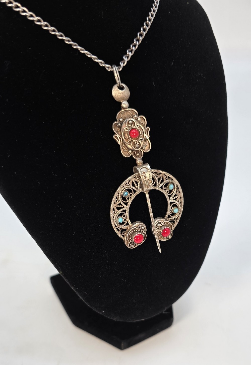 An antique late nineteenth-century French silver pendant in an Ottoman style featuring filigree work set with red and turquoise cabochons, suspended on a silver chain. View III