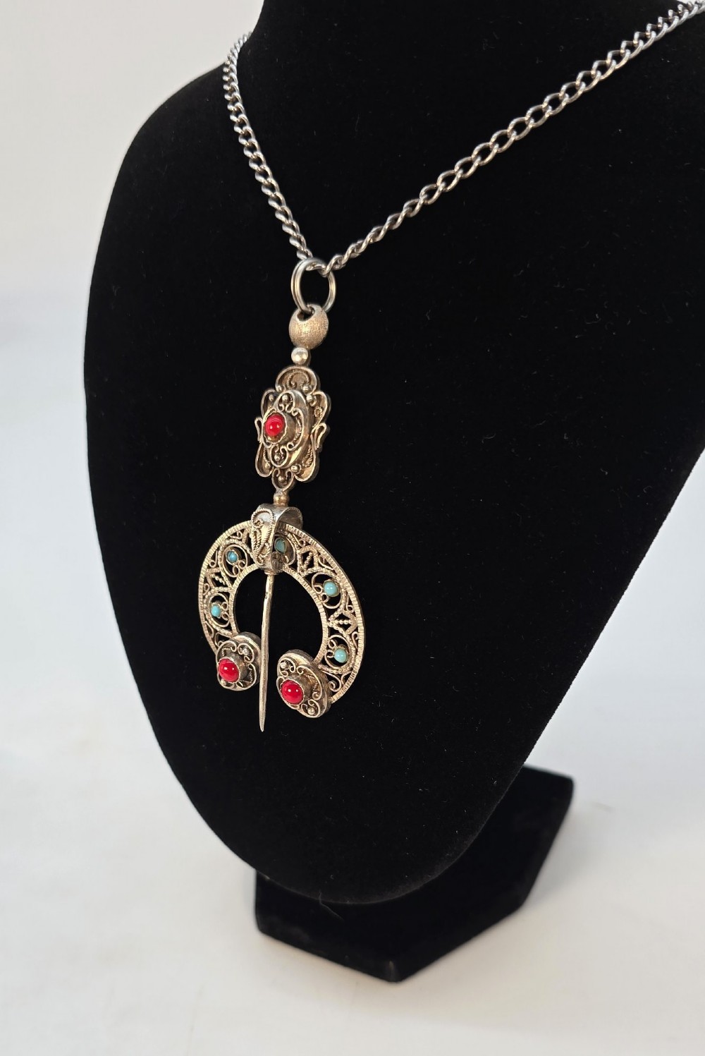 An antique late nineteenth-century French silver pendant in an Ottoman style featuring filigree work set with red and turquoise cabochons, suspended on a silver chain. View IV