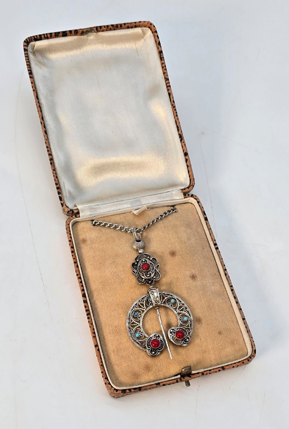 An antique late nineteenth-century French silver pendant in an Ottoman style featuring filigree work set with red and turquoise cabochons, suspended on a silver chain. View VI