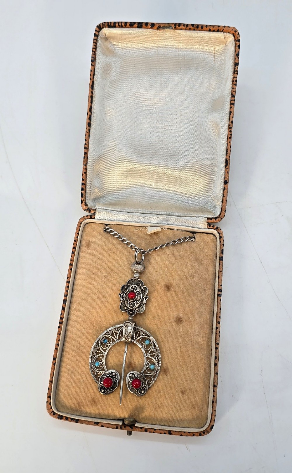 An antique late nineteenth-century French silver pendant in an Ottoman style featuring filigree work set with red and turquoise cabochons, suspended on a silver chain. View VII