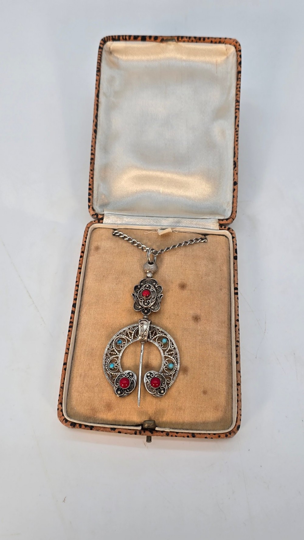An antique late nineteenth-century French silver pendant in an Ottoman style featuring filigree work set with red and turquoise cabochons, suspended on a silver chain. View VIII
