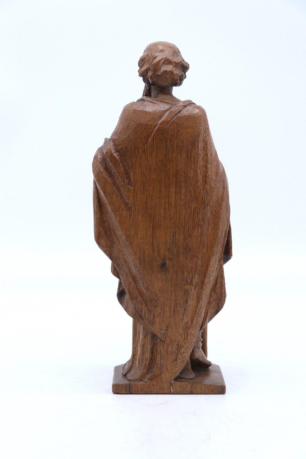 A carved oak wooden statue depicting Saint Paul holding a sword and scroll, standing on an octagonal wooden base. View III