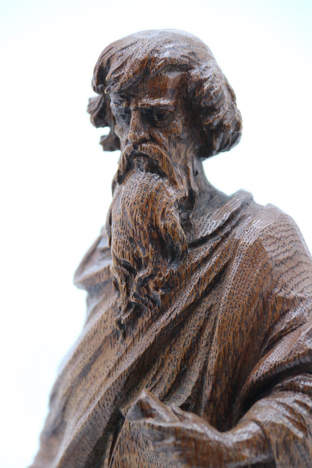 A carved oak wooden statue depicting Saint Paul holding a sword and scroll, standing on an octagonal wooden base. View IX