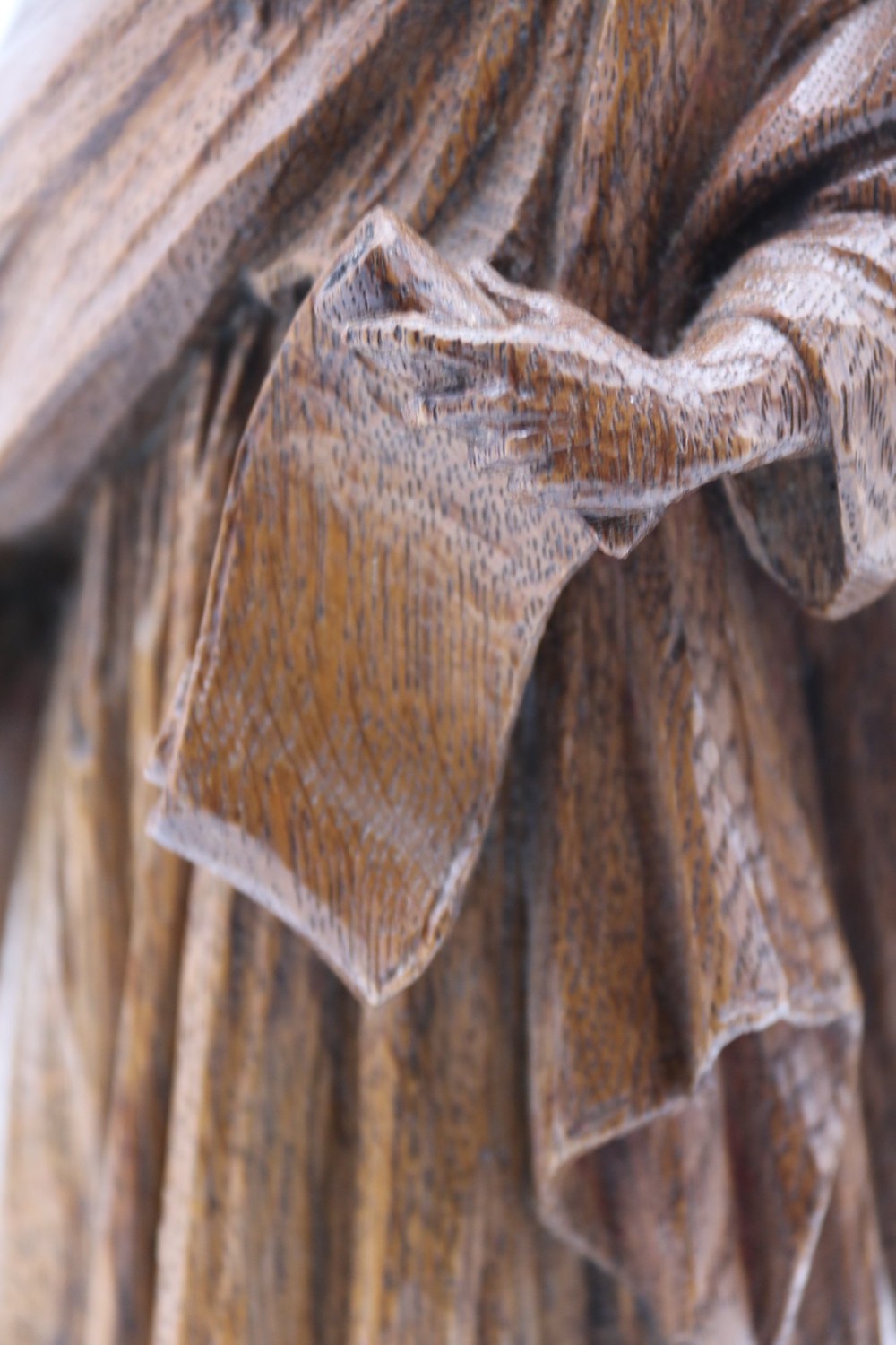 A carved oak wooden statue depicting Saint Paul holding a sword and scroll, standing on an octagonal wooden base. View XII