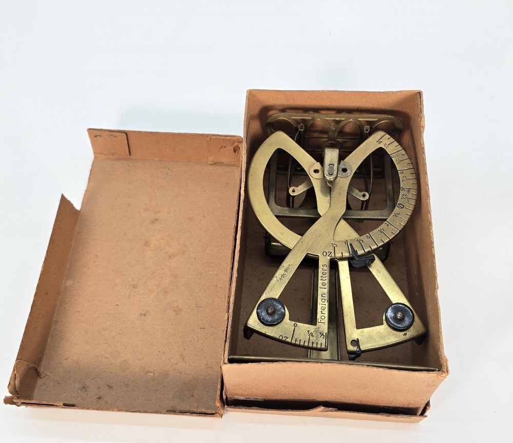 An Edwardian brass postal scale with an engraved curved measurement arc resting on a moulded rectangular base. View XIII