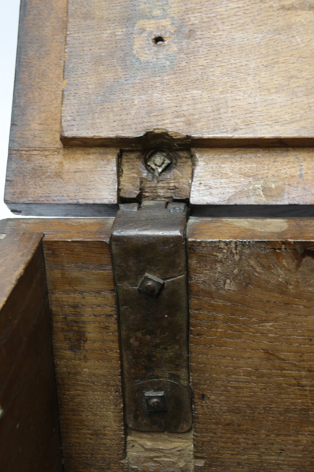 A dark carved oak strong box featuring metal binding straps, side drop handles, and relief carvings of figures and foliage. View XI