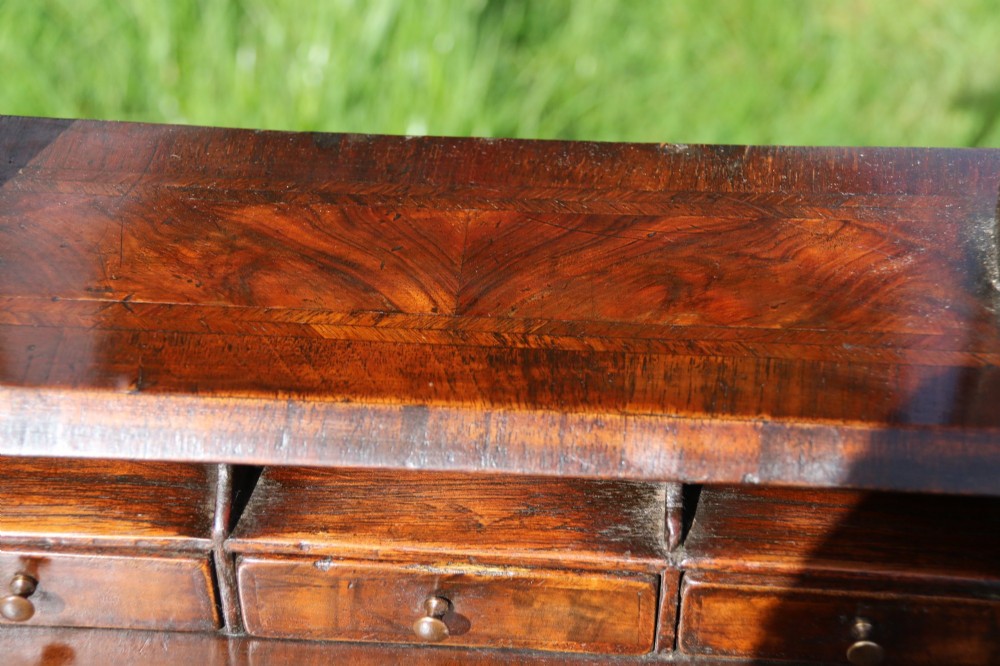 A Victorian figured walnut table mirror featuring an arched swivelling glass set above a slant-front miniature bureau base with a lower drawer. View IV