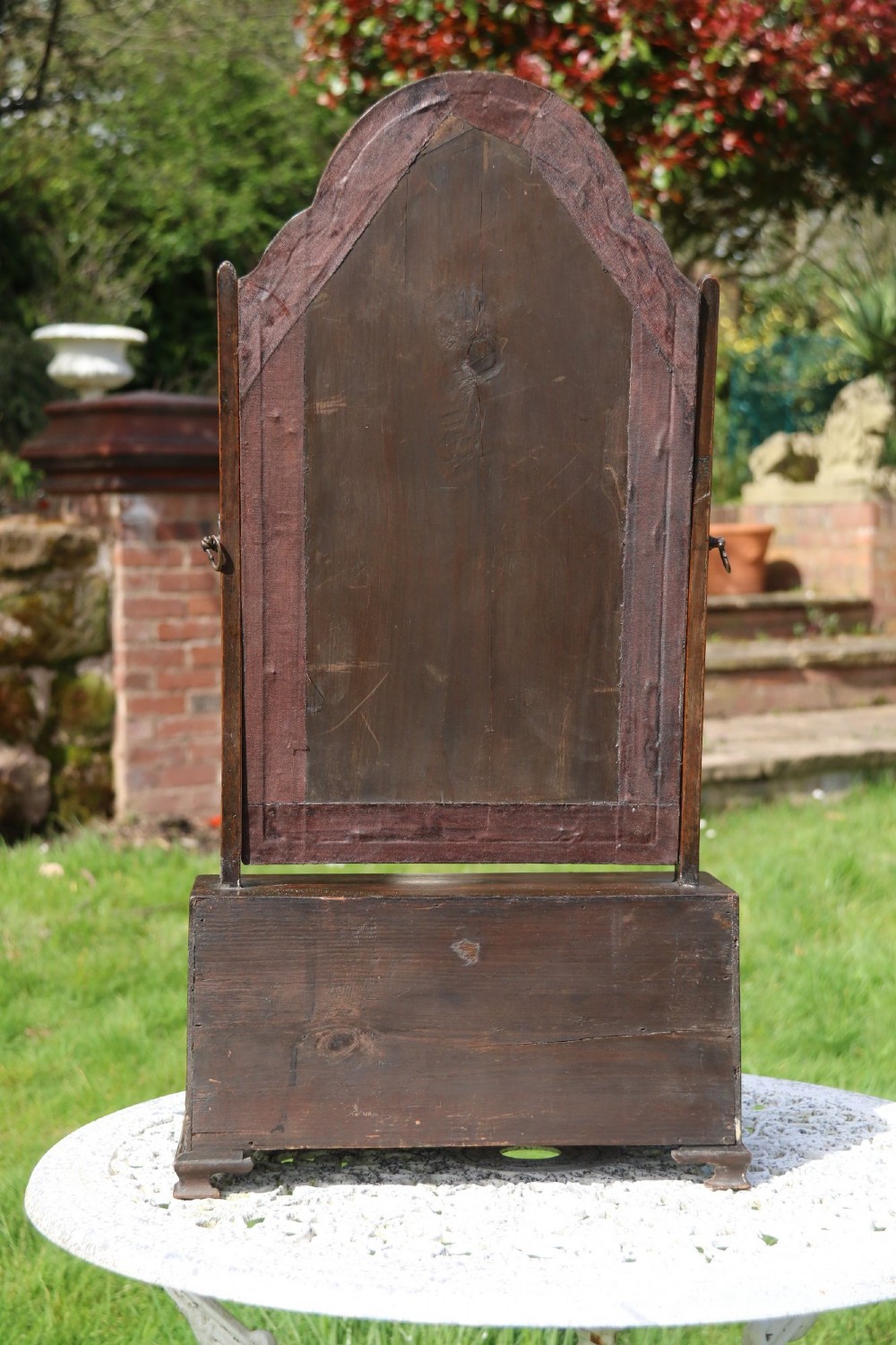 A Victorian figured walnut table mirror featuring an arched swivelling glass set above a slant-front miniature bureau base with a lower drawer. View VII