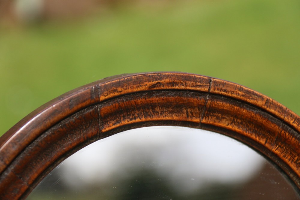 A Victorian figured walnut table mirror featuring an arched swivelling glass set above a slant-front miniature bureau base with a lower drawer. View X