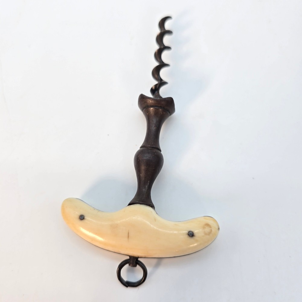An early nineteenth-century corkscrew featuring a curved cream-coloured bone handle and a turned dark wood shaft with a steel helix. View V