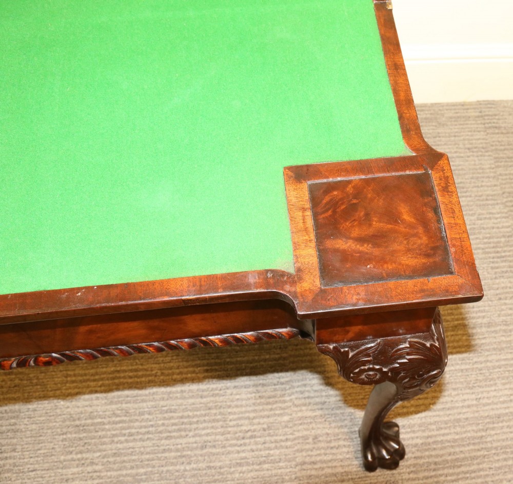 An 18th-century mahogany fold-out card table with a green baize inset top, corner candle stands, and carved cabriole legs ending in claw and ball feet. View IV