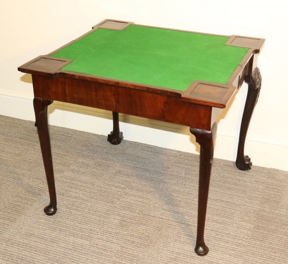 An 18th-century mahogany fold-out card table with a green baize inset top, corner candle stands, and carved cabriole legs ending in claw and ball feet. View VI