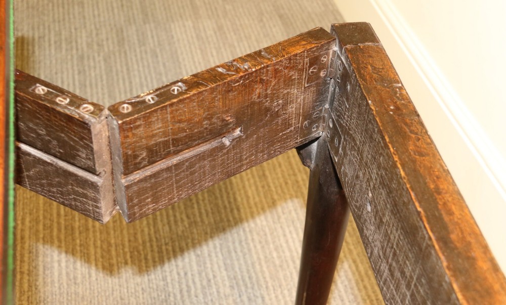 An 18th-century mahogany fold-out card table with a green baize inset top, corner candle stands, and carved cabriole legs ending in claw and ball feet. View X