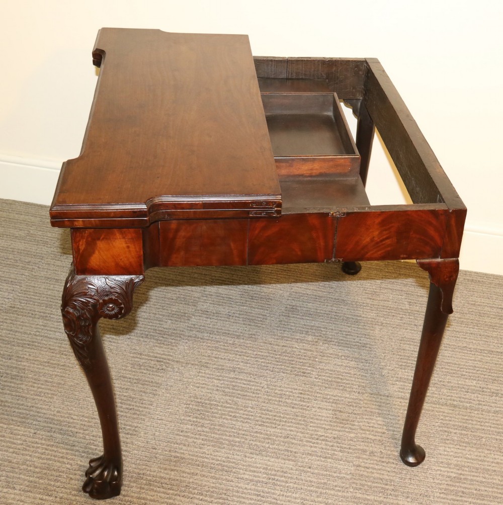An 18th-century mahogany fold-out card table with a green baize inset top, corner candle stands, and carved cabriole legs ending in claw and ball feet. View XI