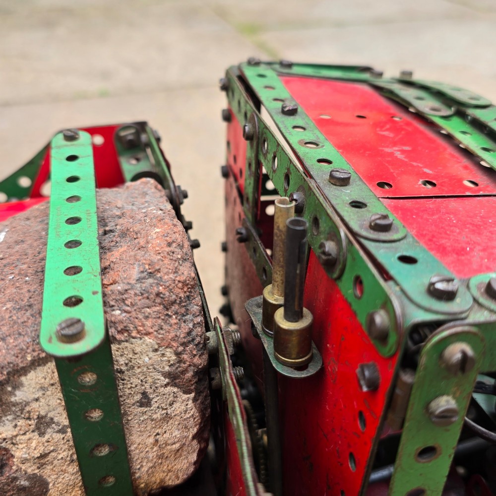 A detailed 1930s red and green Meccano model truck with a loaded timber trailer. View VII