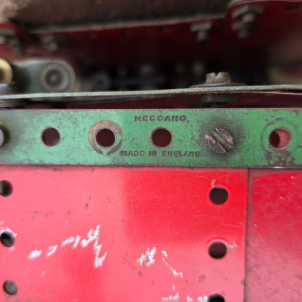A detailed 1930s red and green Meccano model truck with a loaded timber trailer. View IX