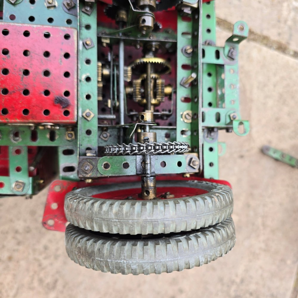 A detailed 1930s red and green Meccano model truck with a loaded timber trailer. View XIII