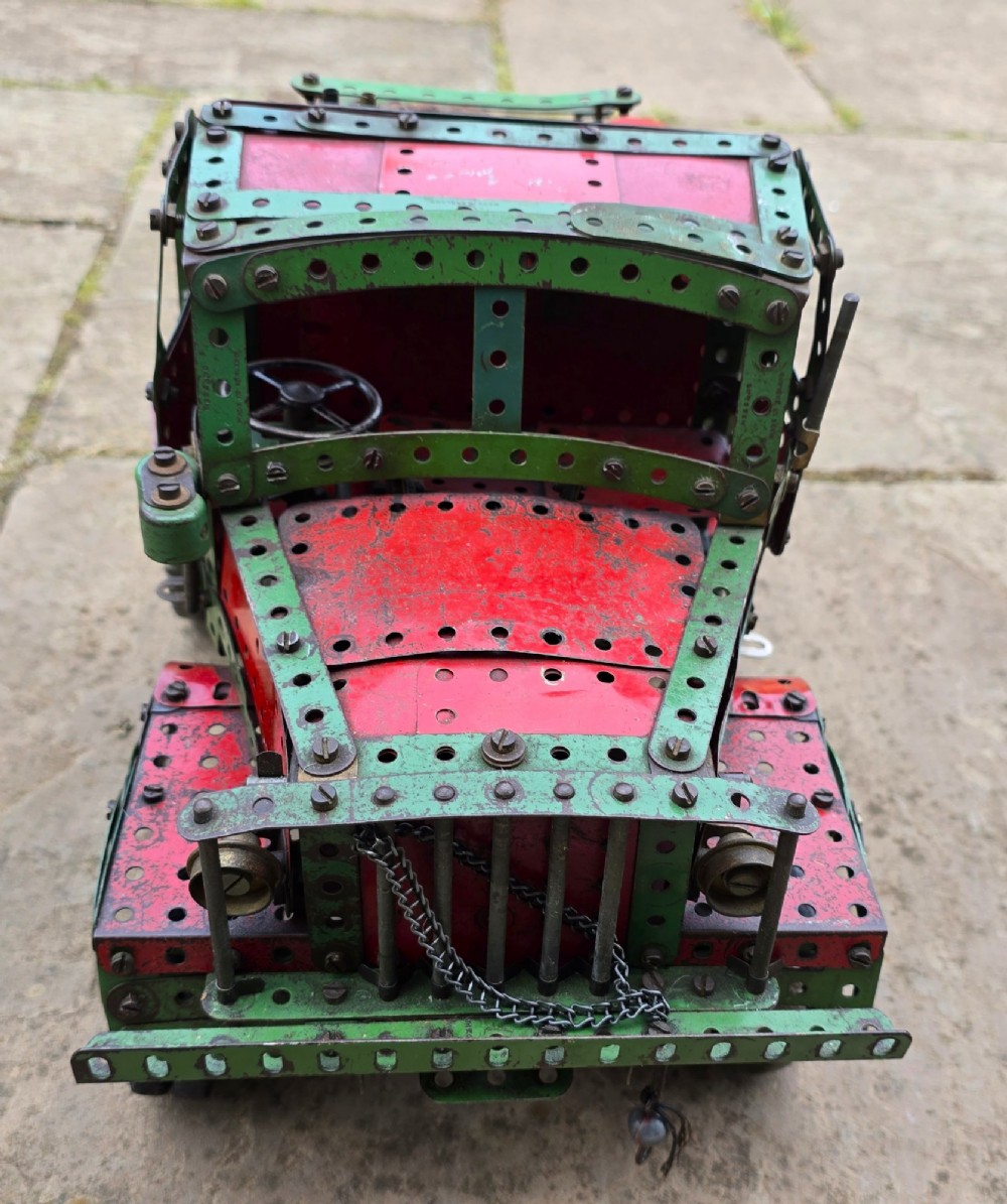 A detailed 1930s red and green Meccano model truck with a loaded timber trailer. View XV