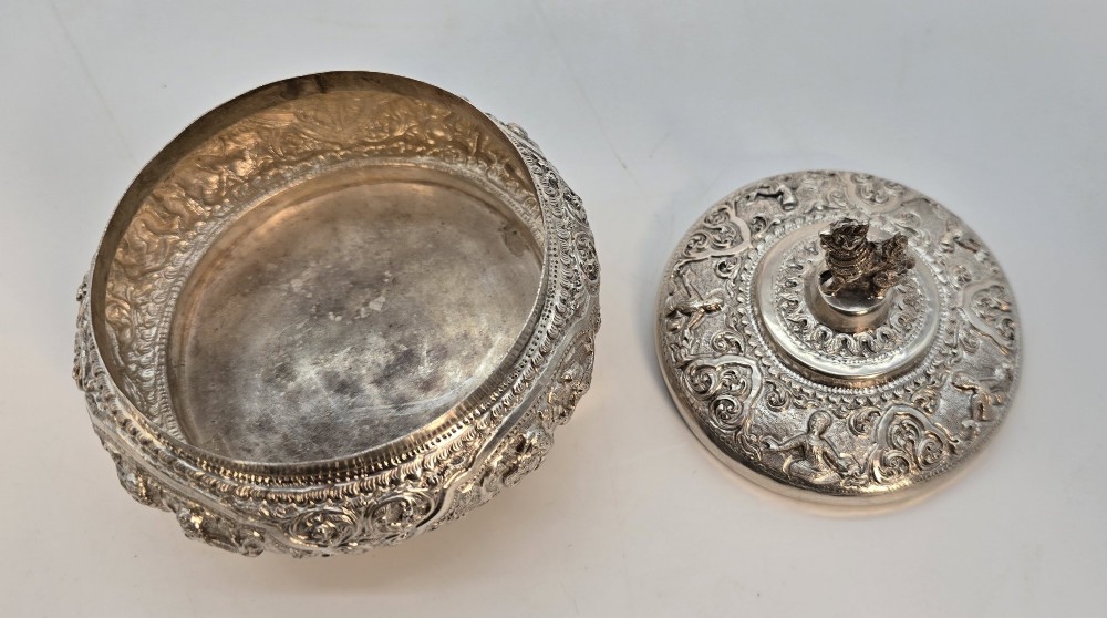 A circular Anglo-Indian chased silver jar featuring ornate scrollwork detailing and a small animal finial on the lid. View VI