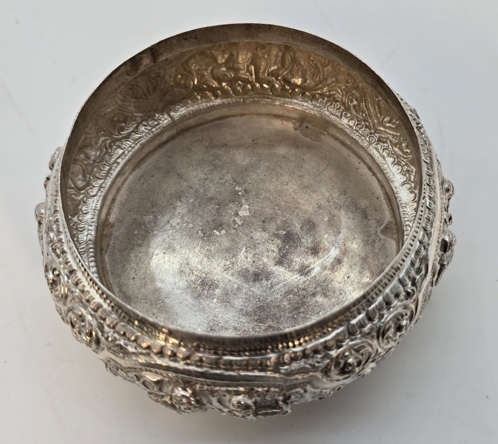 A circular Anglo-Indian chased silver jar featuring ornate scrollwork detailing and a small animal finial on the lid. View VIII