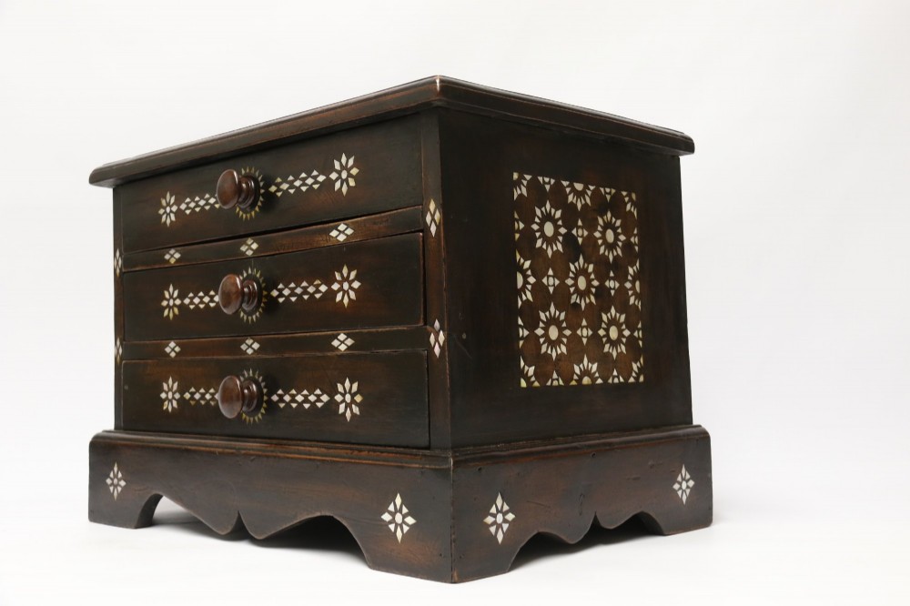 A dark hardwood tabletop chest featuring three drawers decorated with geometric bone inlay and turned wooden knobs. View IV