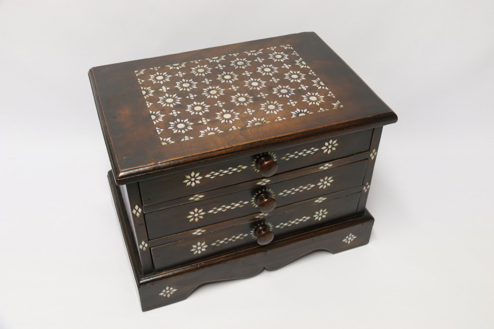 A dark hardwood tabletop chest featuring three drawers decorated with geometric bone inlay and turned wooden knobs. View IX